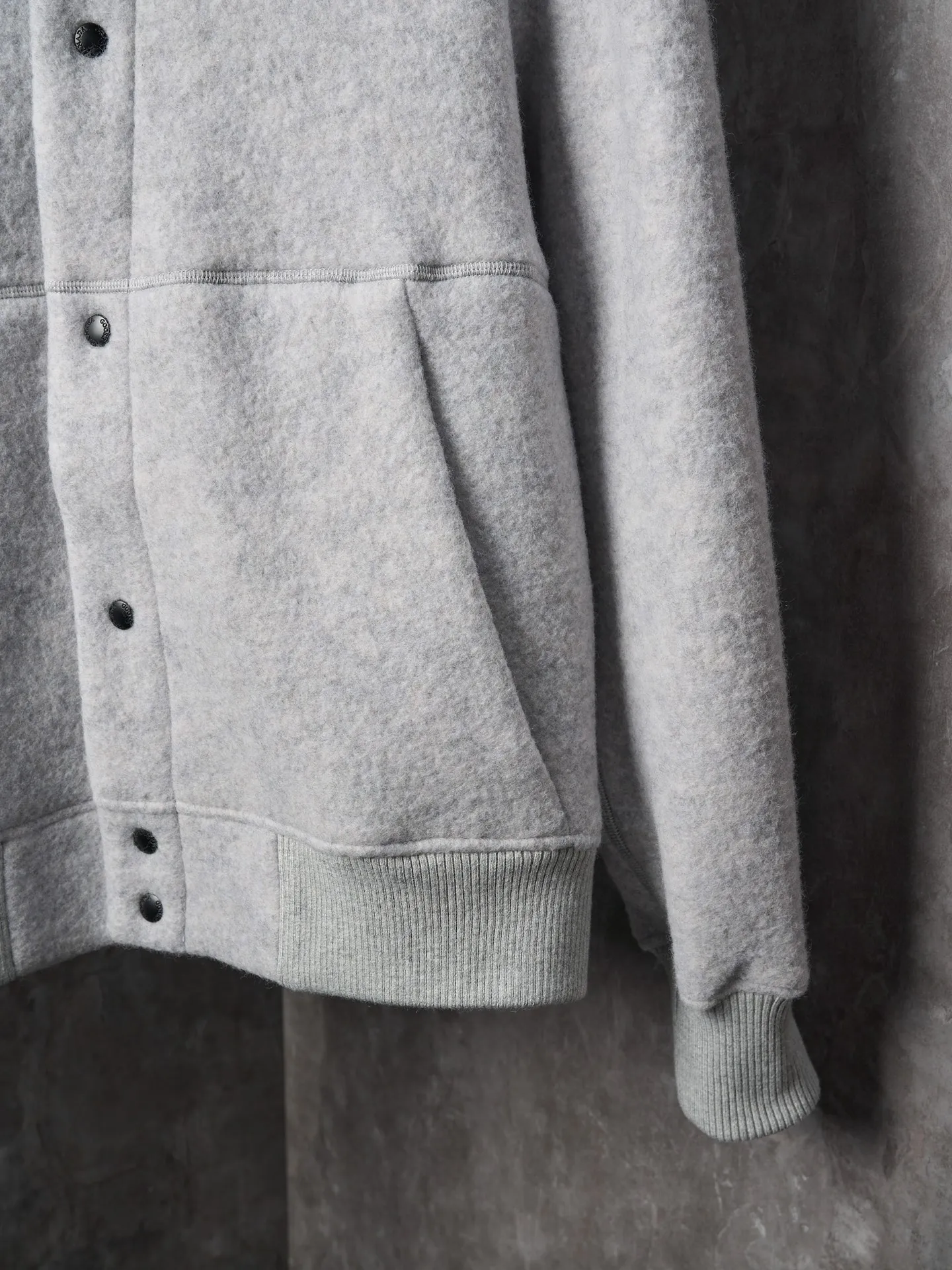 P760 Actual hanging auction] Canada Goose/Canada Goose Fleece Badge Button Cashmere Jacket [Color] Dark Gray Light Gray [Size] S M L XL Wool Blend Fabric: The main fabric of this jacket is light gray wool blend fabric to improve the wear resistance, wrinkle resistance and warmth of the fabric. Wool provides good warmth and a natural feel, while blended fibers enhance the fabric's practicality and durability.  RIBBED KNIT: The collar, cuffs and hem are ribbed knitted for added stretch and fit.  The cutting process needs to ensure that the texture and color of the fabric are evenly distributed, especially with this light gray tone, to avoid chromatic aberrations. The stretchability of wool-blend fabrics needs to be taken into consideration when cutting pieces to ensure dimensional stability of the finished garment.      Use a sewing needle and thread suitable for wool-blend fabrics to avoid damage to the fabric during sewing. The sewing stitches are even and firm to prevent thread stripping.      The temperature needs to be controlled during ironing to avoid high temperature damage to the fabric while keeping the fabric smooth and crisp.   The front and back body parts, sleeves and other main parts are stitched with flat seams to ensure a smooth silhouette.   Align the fabric texture at the splices to keep the look neat.     Details such as pockets and cuffs are designed with inset pockets to increase practicality and aesthetics.     The splicing areas are reinforced to improve durability.  The white circular armband on the left arm is an important part of the brand identity and is finely sewn to ensure it is strong and flat.